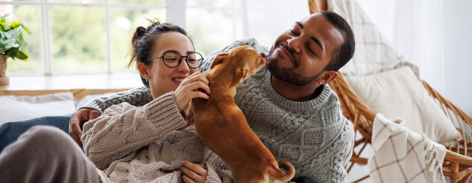 a man and woman lying on a couch with a dog