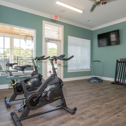 a fitness studio with stationary bikes and tv's